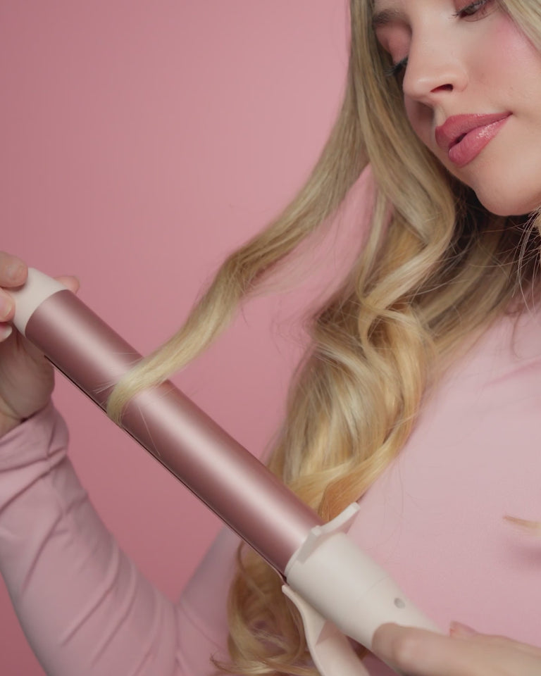 model on pink background using pink curling iron